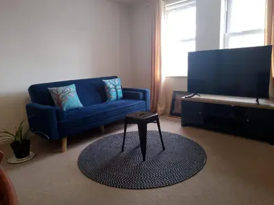 a living room with a blue couch and a table at 2 Bed - Sleeps 4 - Free Parking in Ely