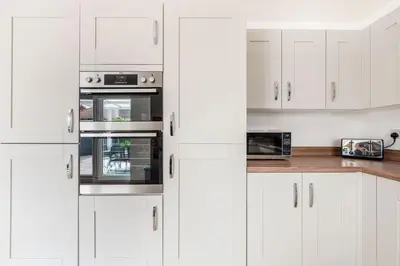 a white kitchen with white cabinets and appliances at 4 Bed, 3 Bath Townhouse in Colchester - Business, Contractor and Leisure - Singles or Superkings - Disc0unts in Lexden