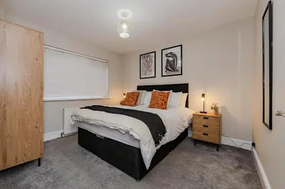 a bedroom with a large bed and a window at New 4BR Gem, Central, 3 Car Drive, Contractor Stay in South Benfleet
