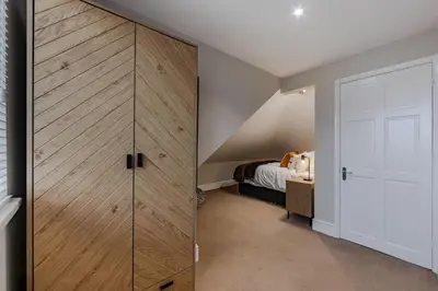 a bedroom with a sliding closet door and a bed at New 4BR Gem, Central, 3 Car Drive, Contractor Stay in South Benfleet