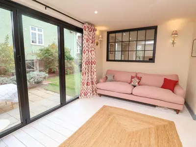 a living room with a pink couch and windows at 52 Lee Road in Aldeburgh