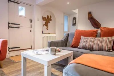 a living room with a couch and a table at The Secret Cottage, Aldeburgh in Aldeburgh
