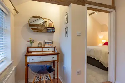 a bedroom with a bed and a table with a mirror at 1 Bed in Scole oc-a34355 in Scole