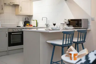 a kitchen with two blue bar stools and a microwave at 1 Bed in Scole oc-a34355 in Scole