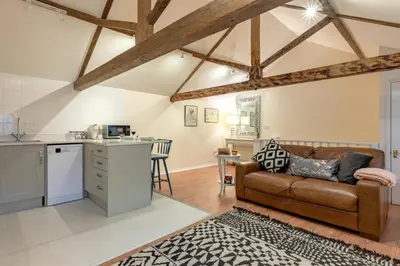 a living room with a brown couch in a kitchen at 1 Bed in Scole oc-a34355 in Scole