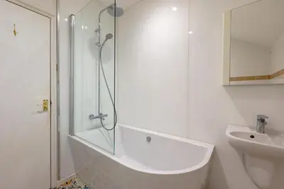 a white bathroom with a shower and a sink at 1 Bed in Scole oc-a34355 in Scole