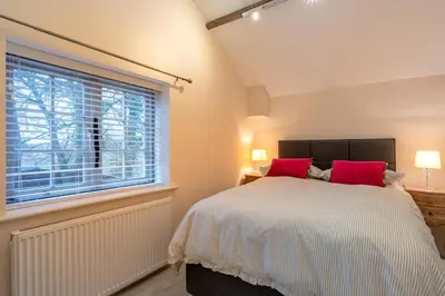 a bedroom with a bed with red pillows and a window at 1 Bed in Scole oc-a34355 in Scole