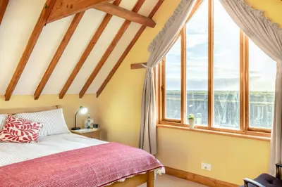 a bedroom with a bed and large windows at 1 Bed in Orford oc-m34121 in Orford
