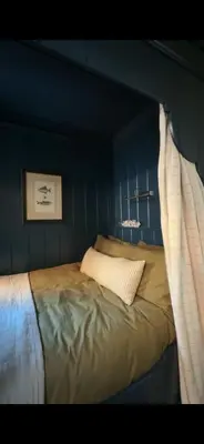 a bed in a room with a blue wall at Sunray House - Sea View, Beach Front Holiday Home in Felixstowe