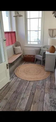 a living room with a rug on a wooden floor at Sunray House - Sea View, Beach Front Holiday Home in Felixstowe