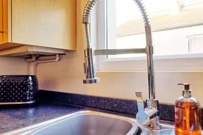 a sink in a kitchen with a window at Cosy 2 Bedroom Flat Near Westcliff On Sea Beach & Hamlet Court Road in Southend-on-Sea