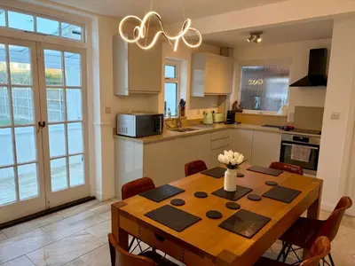 a kitchen with a wooden table and a dining room at City Centre, En-Suite, 3 Doubles 1 Single, 2 Car Parking in Colchester