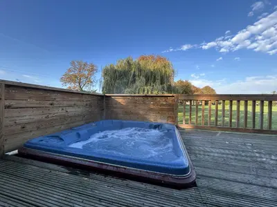 a hot tub sitting on top of a deck at Athelington Lodge - Oak in Eye