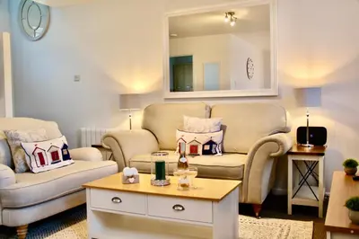 a living room with two couches and a table at Seaside Luxury Cottage Aldeburgh in Aldeburgh
