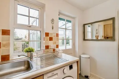 a kitchen with a sink and a mirror at Seaside Luxury Cottage Aldeburgh in Aldeburgh