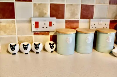 a row ofools with cats figurines on a kitchen counter at Seaside Luxury Cottage Aldeburgh in Aldeburgh