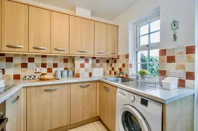 a kitchen with a washing machine and a window at Seaside Luxury Cottage Aldeburgh in Aldeburgh