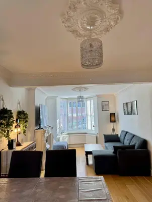 a living room with a couch and a chandelier at Three Bees in Hythe