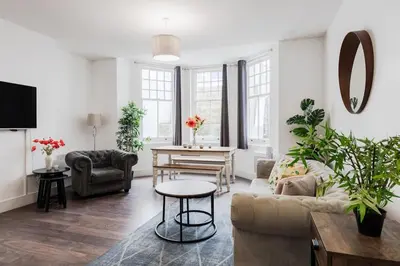a living room with a couch and a table at The Regency | Seafront Lux Apartments! in Southend-on-Sea