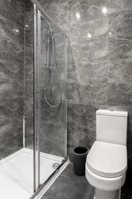 a bathroom with a toilet and a glass shower at The Regency | Seafront Lux Apartments! in Southend-on-Sea
