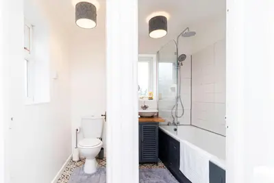 a bathroom with a toilet and a tub and a sink at Beautiful 3 Bedroom Home with Parking & Garden in Colchester