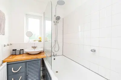 a bathroom with a tub and a sink and a shower at Beautiful 3 Bedroom Home with Parking & Garden in Colchester