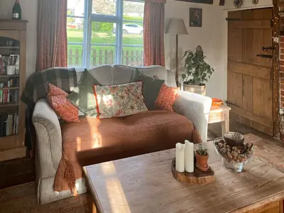a living room with a couch and a coffee table at Hill House in Colchester