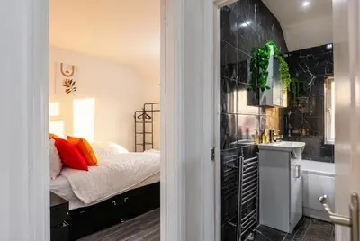 a bedroom with a bed and a sink and a tub at Spacious 3-Bed Home for 8 | Free Parking & Garden in Havering atte Bower