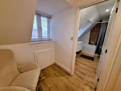 a living room with a chair and a staircase at Modern home close to amenities and transport links in Wymondham