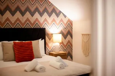 a bedroom with a bed with a chevron wall at Stylish Modern Home in City Centre Free Parking - Pass the Keys in Cambridge