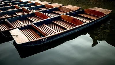 two wooden boats sitting in the water at Luxury new build house nearr Science and Business parks in Cambridge