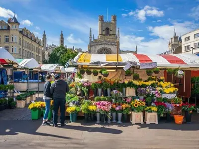 two people standing in front of a market with flowers at Luxury new build house nearr Science and Business parks in Cambridge
