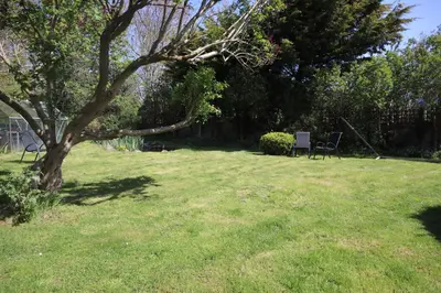 a yard with two chairs and a tree at Comfortable Homestay by Earith Lakes in Earith