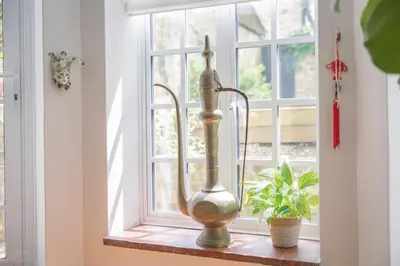 a vase sitting on a window sill next to a plant at Central Victorian Villa 2 Floor I Parking I Garden in Cambridge