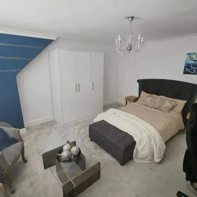 a bedroom with a large bed and a table at Luv home with pool and cinema room
