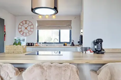 a kitchen with a table and a clock on the wall at Luxury Apartment- Beach 10mins in Thorpe Bay