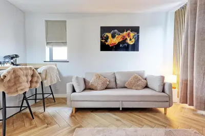 a living room with a couch and a painting on the wall at Luxury Apartment- Beach 10mins in Thorpe Bay