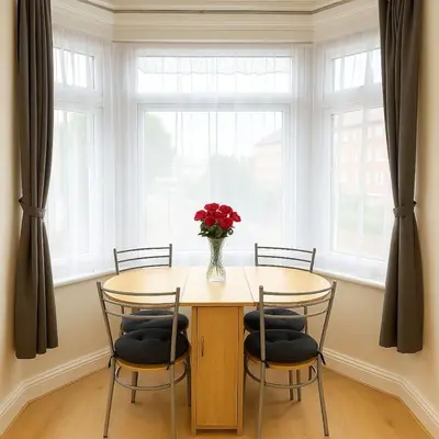 a dining room table with a vase of flowers on it at 1 Bed Service Accommodation- contractor ready in Southend-on-Sea