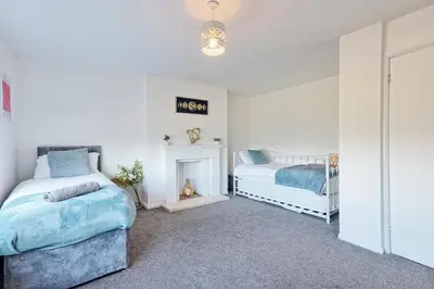 a bedroom with two beds and a fireplace at Modern 4BR Sleeps 10, Free Parking, Basildon town, Contractor friendly in Basildon