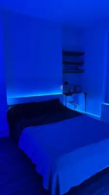 a blue room with a bed with a blue light at 52A Flat Mill Road in Cambridge