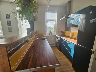 a kitchen with blue cabinets and a wooden counter top at Station House in Roudham
