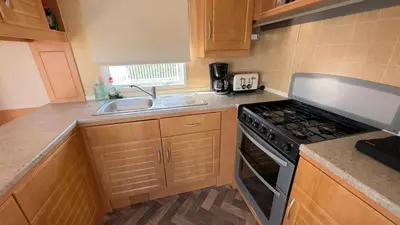 a small kitchen with a stove and a sink at Suntrail House in Great Clacton