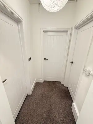 an empty hallway with two white doors and a carpet at The Coral Stay By Cambridge Central Station in Cambridge