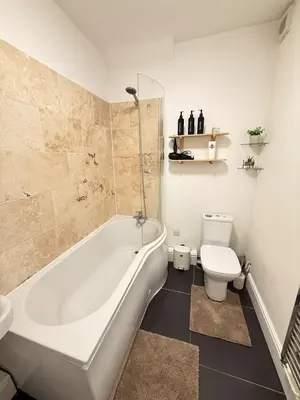 a bathroom with a white tub and a toilet at The Coral Stay By Cambridge Central Station in Cambridge