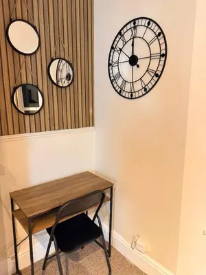 a table and two clocks on the wall at The Coral Stay By Cambridge Central Station in Cambridge