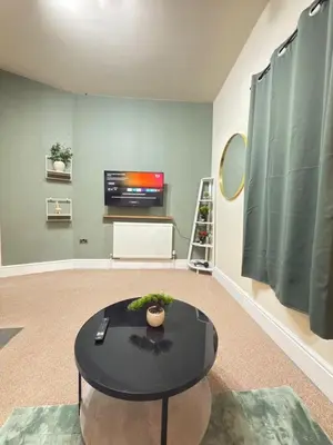 a living room with a table and a tv at The Modern Nest By Cambridge Central Station in Cambridge