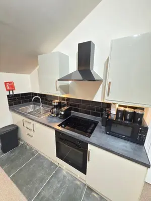 a kitchen with a stove top oven next to a sink at The Modern Nest By Cambridge Central Station in Cambridge