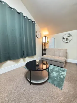 a living room with a couch and a table at The Modern Nest By Cambridge Central Station in Cambridge