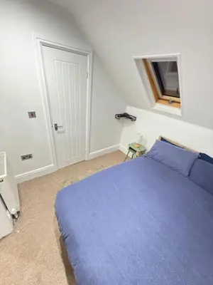 a bedroom with a blue bed and a window at The Traveller's Nest by Cambridge Central Station in Cambridge