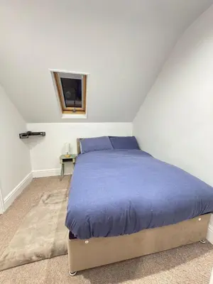 a bedroom with a bed and a tv on the wall at The Traveller's Nest by Cambridge Central Station in Cambridge